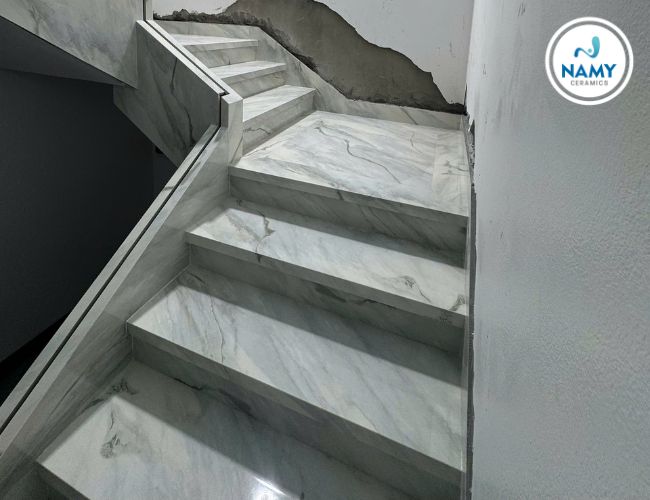 Cầu thang ốp đá Bianco Lasa mặt bóng âm kính. 