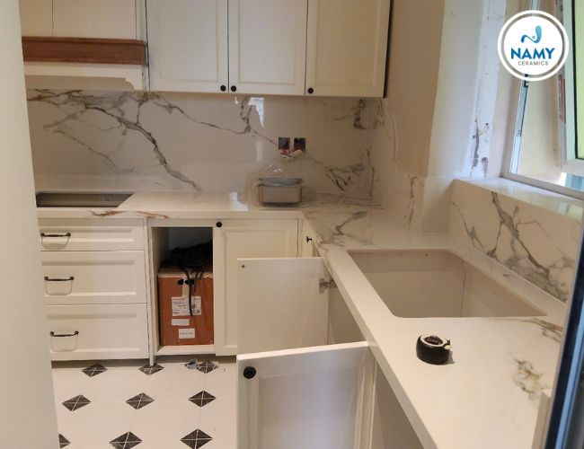 Bàn bếp và tường bếp ốp đá nung kết nền trắng vân mây to.