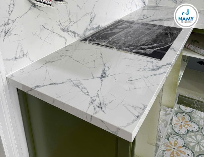 Phối đá nung kết vân mây trắng với nội thất tông xanh hài hòa dịu mắt.