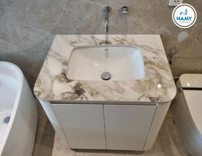 Lavabo phòng tắm cũng tận dụng đá Volkas Grigio.